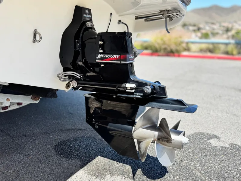 Slide: The Image of Outboard motor of 2004 Maxum 2500 SE boat with Mercury branding, parked on pavement. - 9