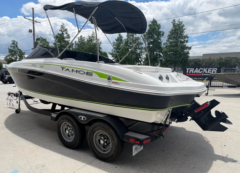 Slide: The Image of 2019 Tahoe 700 boat on trailer, black and white design, outdoor setting. - 2