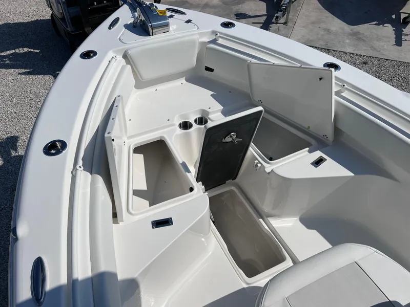 Slide: The Image of 2025 Key West 239FSR boat interior with open storage compartments and cup holders. - 14