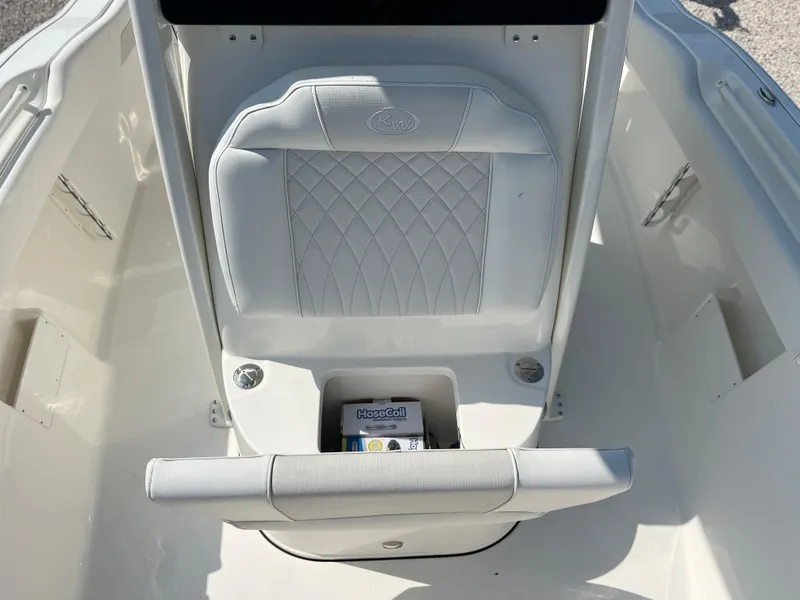 Slide: The Image of 2025 Key West 239FSR boat interior with white cushioned seating and storage compartment. - 20