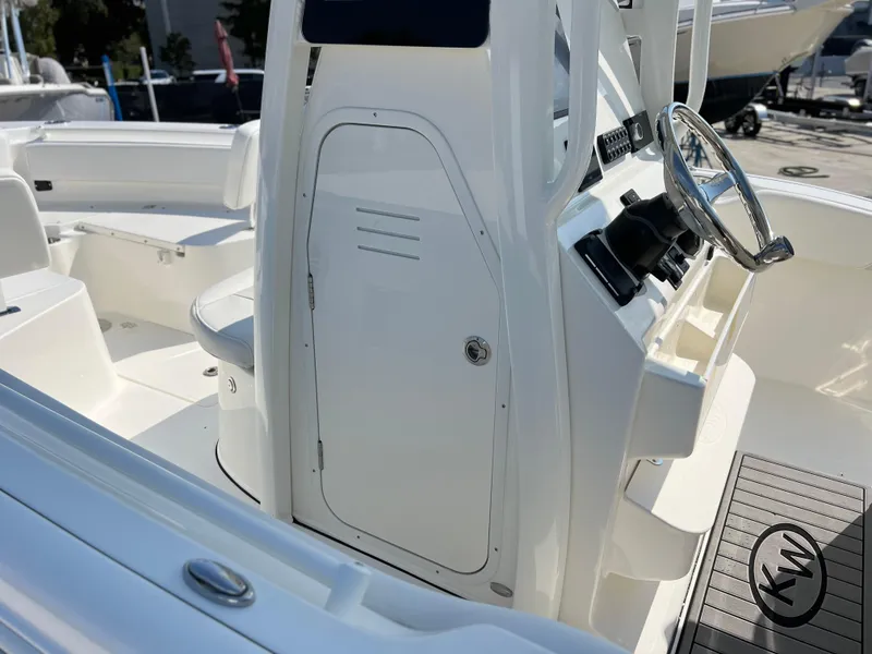 Slide: The Image of 2025 Key West 239FSR boat interior with steering wheel and seating area. - 23