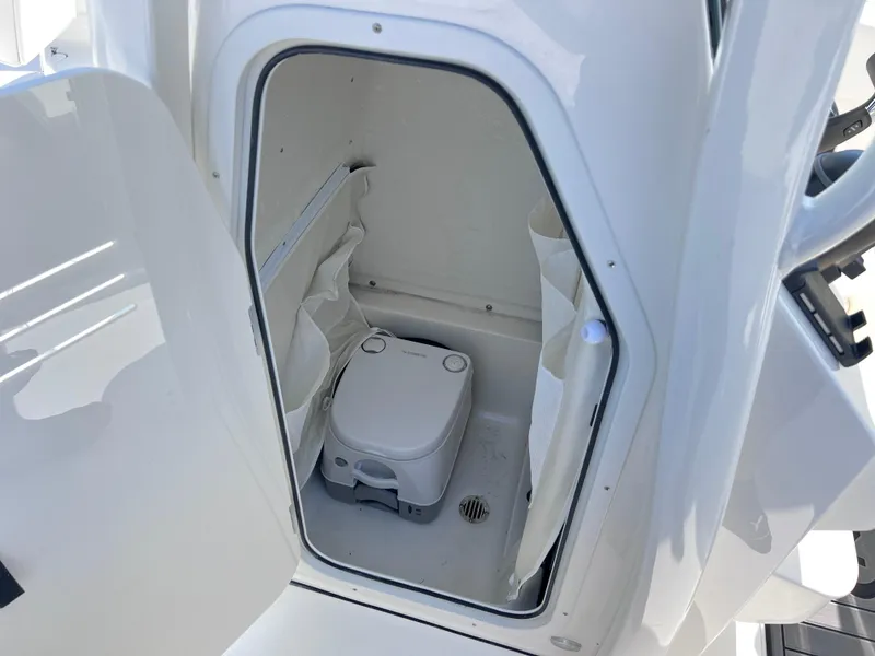 Slide: The Image of 2025 Key West 239FSR boat interior with compact marine toilet. - 24