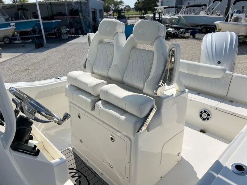Slide: The Image of 2025 Key West 239FSR boat interior with white cushioned seating and steering wheel. - 25