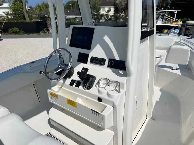 Slide: The Image of 2025 Key West 239FSR boat console with steering wheel, Garmin display, and cup holders. - 31