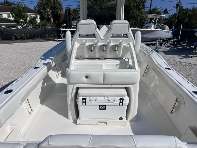 Slide: The Image of 2025 Key West 239FSR boat interior with seating and cooler, parked outdoors. - 39