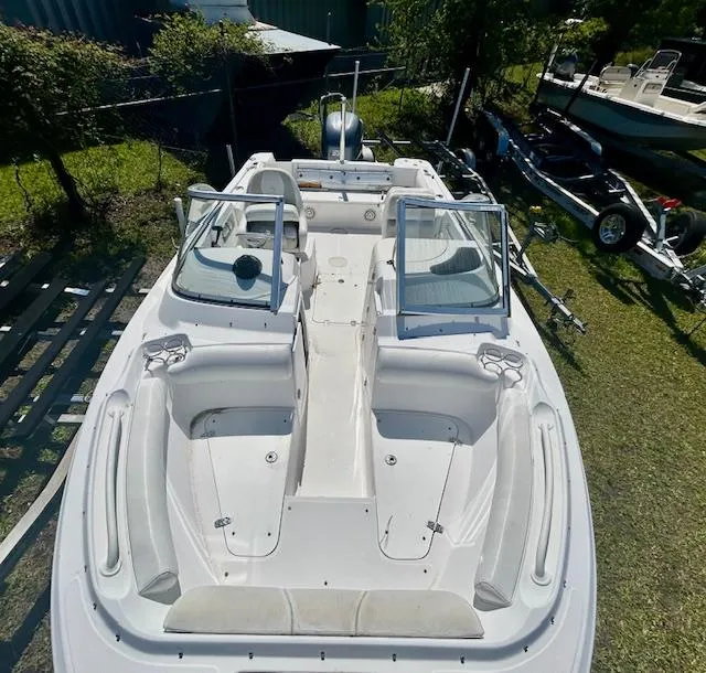 Slide: The Image of 2009 Edgewater 20 CX boat with open seating, viewed from above, parked on grass. - 2