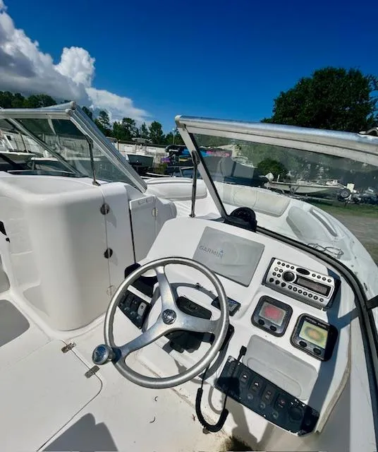 Slide: The Image of 2009 Edgewater 20 CX boat cockpit with steering wheel and control panel under clear blue sky. - 4
