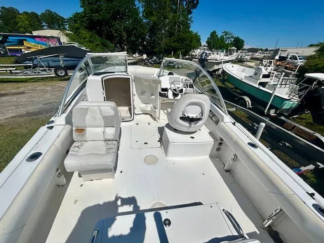 Slide: The Image of 2009 Edgewater 20 CX boat interior with seating and steering, docked outdoors. - 6
