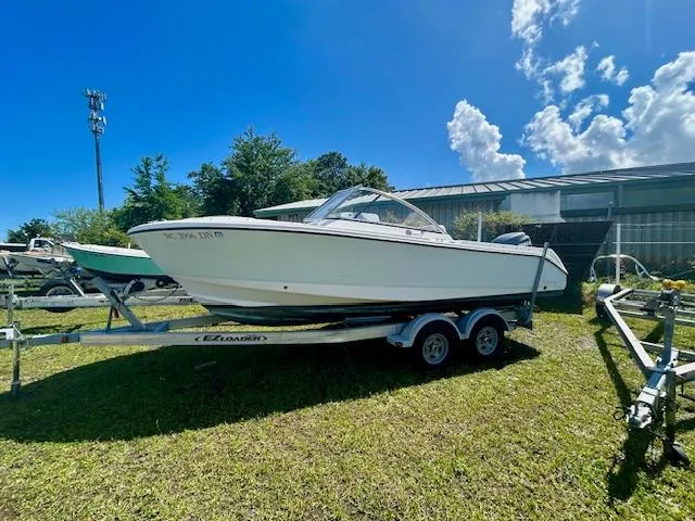 Slide: The Image of 2009 Edgewater 20 CX boat on trailer, parked on grass under a clear blue sky. - 9