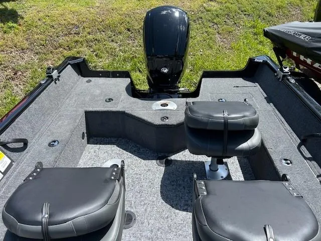 Slide: The Image of 2025 Tracker Pro Guide V-16 SC boat interior with seating and motor, on grassy background. - 3