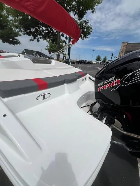 Slide: The Image of 2023 Tahoe T18 boat with Mercury Pro XS engine, docked outdoors under a clear sky. - 10