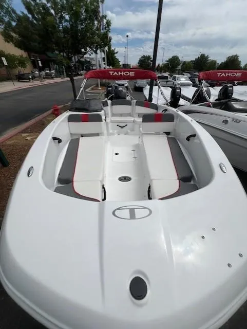Slide: The Image of 2023 Tahoe T18 boat with red accents, docked outdoors on a cloudy day. - 4