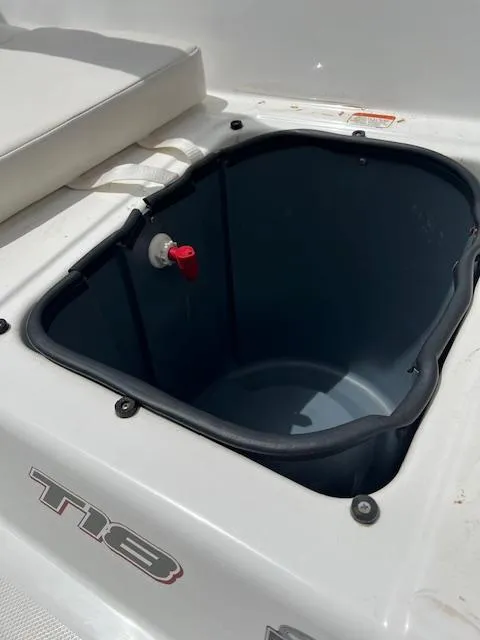 Slide: The Image of 2023 Tahoe T18 boat storage compartment with red valve, white interior. - 6