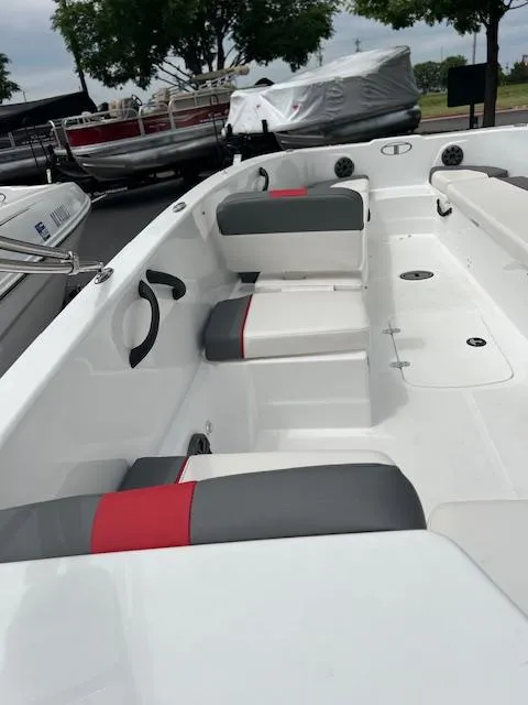 Slide: The Image of 2023 Tahoe T18 boat interior with gray and red seating, docked outdoors. - 8