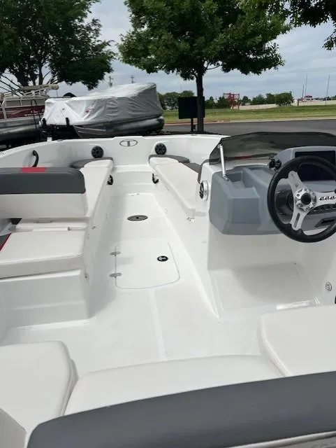 Slide: The Image of 2023 Tahoe T18 boat interior with seating and steering wheel, parked outdoors. - 9