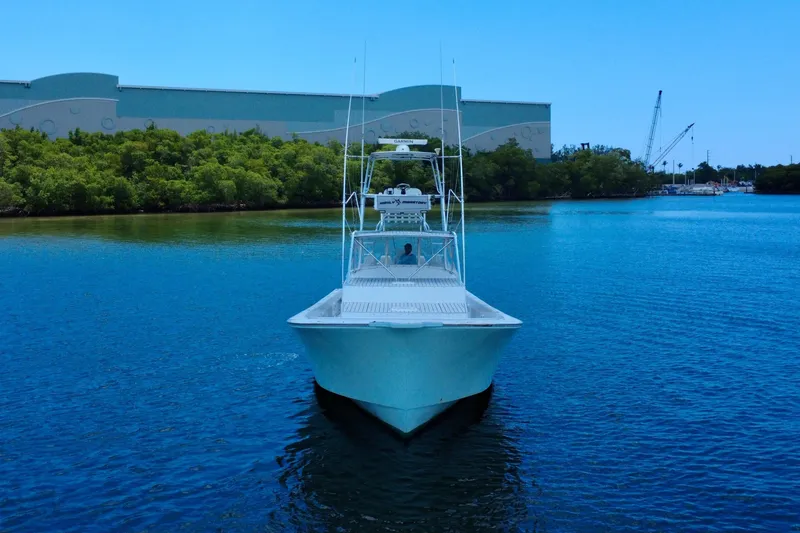 Slide: The Image of 2017 Chesapeake 53 Center Console boat on calm water, surrounded by greenery and industrial buildings. - 13