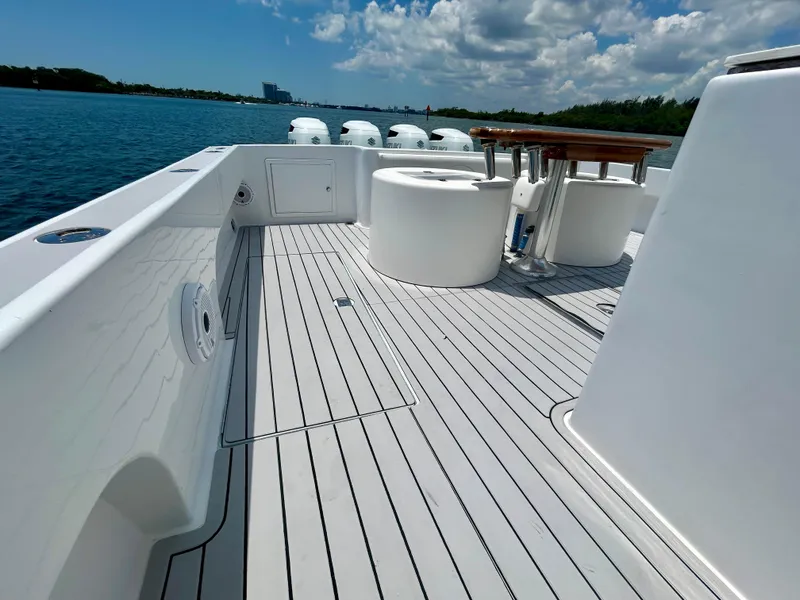 Slide: The Image of 2017 Chesapeake 53 Center Console boat deck with seating, on a sunny day by the water. - 24