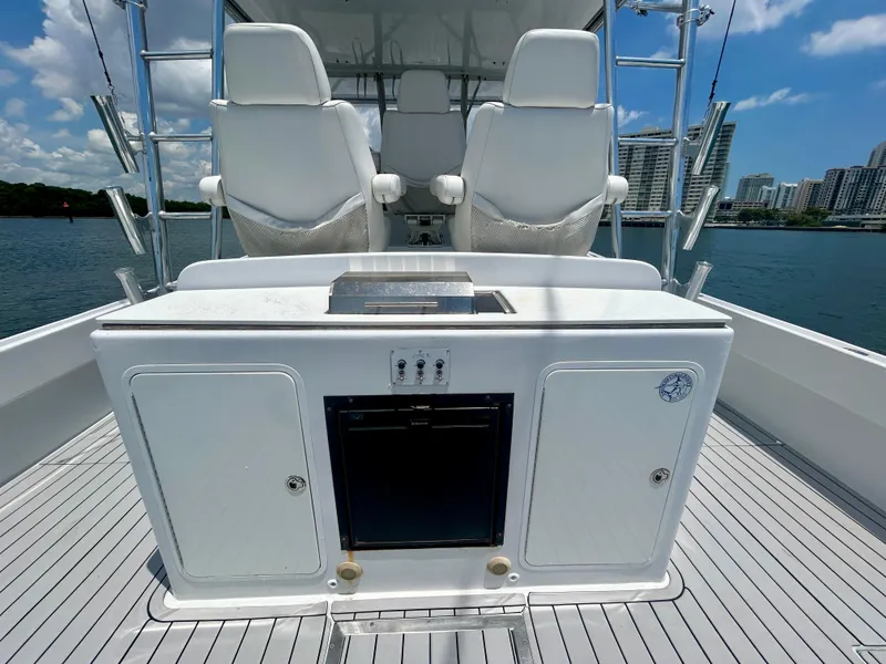 Slide: The Image of 2017 Chesapeake 53 Center Console boat interior with seating and storage, docked near cityscape. - 28