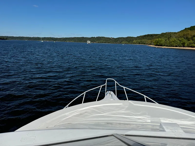 Slide: The Image of Bow view of 1996 Skipperliner 560 Coastal Cruiser on a serene lake. - 10