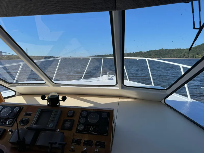 Slide: The Image of 1996 Skipperliner 560 Coastal Cruiser helm view, navigating a river with clear skies. - 15