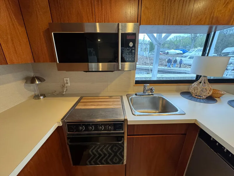 Slide: The Image of 1996 Skipperliner 560 Coastal Cruiser kitchen with microwave, stove, sink, and window view. - 22