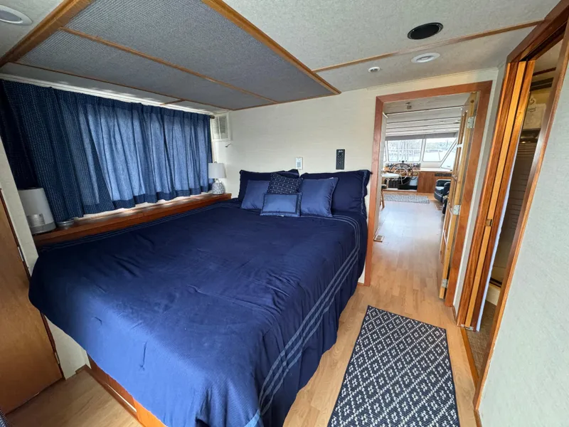 Slide: The Image of Bedroom interior of 1996 Skipperliner 560 Coastal Cruiser with blue bedding and wooden accents. - 28