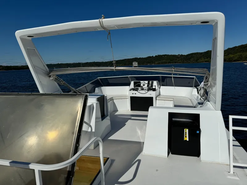 Slide: The Image of 1996 Skipperliner 560 Coastal Cruiser on calm water, featuring spacious deck and helm. - 3