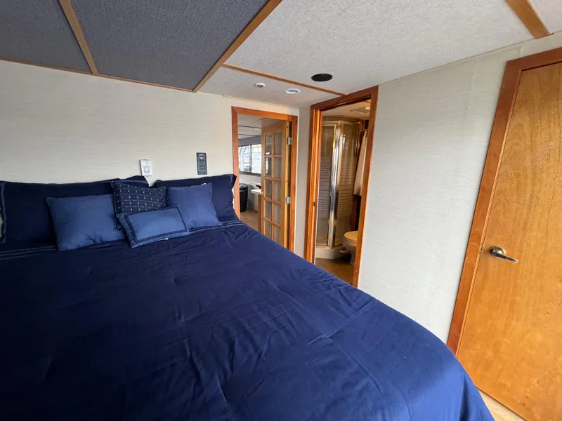 Slide: The Image of Bedroom interior of 1996 Skipperliner 560 Coastal Cruiser with blue bedding and ensuite bathroom. - 32