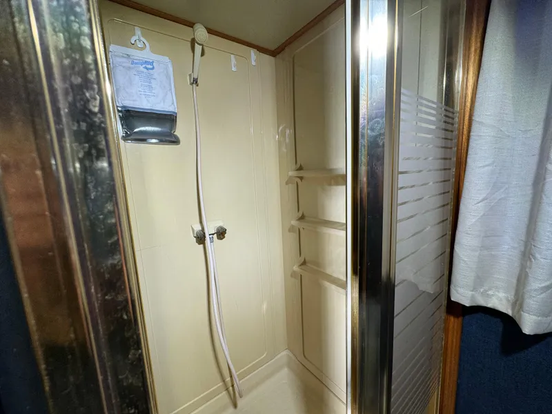 Slide: The Image of Shower area inside 1996 Skipperliner 560 Coastal Cruiser with glass door and wall-mounted fixtures. - 39
