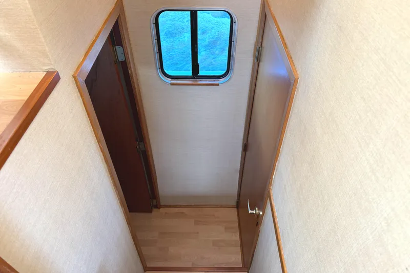Slide: The Image of Narrow hallway with wooden flooring and window on a 1996 Skipperliner 560 Coastal Cruiser. - 43