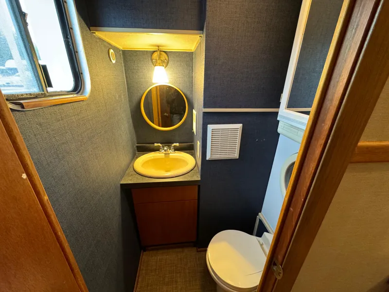 Slide: The Image of Bathroom interior of 1996 Skipperliner 560 Coastal Cruiser with sink, toilet, and mirror. - 44