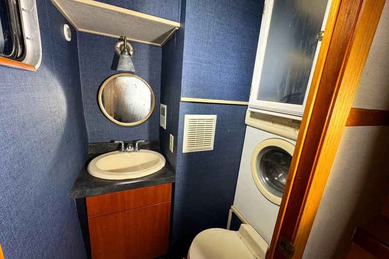 Slide: The Image of Bathroom with sink, mirror, and washer-dryer in 1996 Skipperliner 560 Coastal Cruiser. - 46