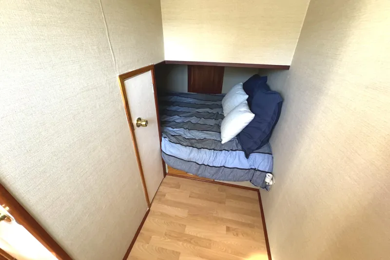Slide: The Image of Cozy bedroom in 1996 Skipperliner 560 Coastal Cruiser with wooden flooring and compact bed. - 47
