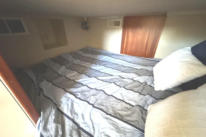 Slide: The Image of Cozy bedroom in 1996 Skipperliner 560 Coastal Cruiser with striped bedding. - 48