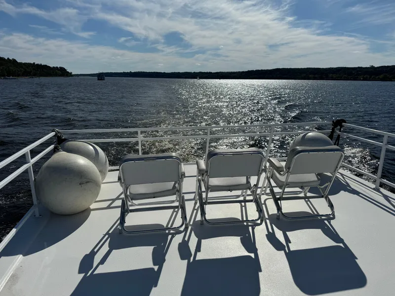 Slide: The Image of 1996 Skipperliner 560 Coastal Cruiser deck with chairs overlooking sparkling water. - 9