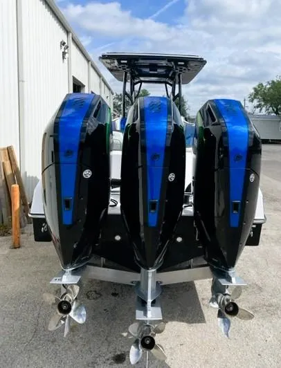 Slide: The Image of 2025 Renegade 38 Open boat with triple outboard engines, docked outdoors. - 15