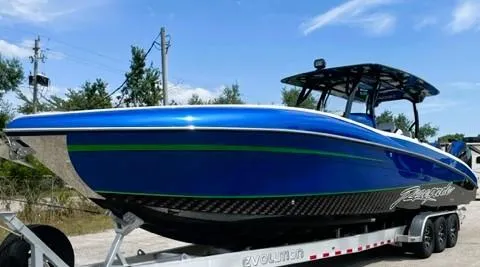 Slide: The Image of 2025 Renegade 38 Open boat in blue on a trailer, under a clear sky. - 16