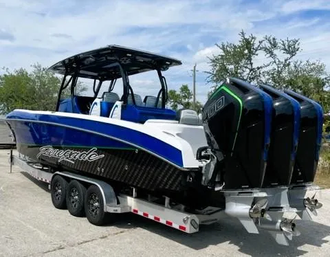 Slide: The Image of 2025 Renegade 38 Open boat on trailer with triple outboard engines, blue and white design. - 17