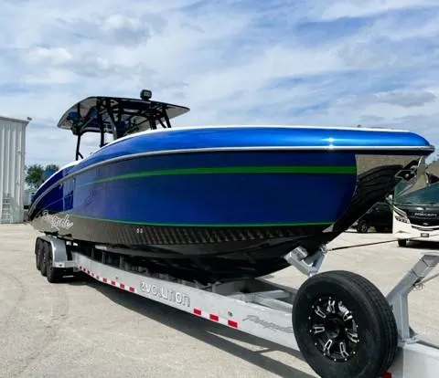 Slide: The Image of 2025 Renegade 38 Open boat on trailer, blue and green design, parked outdoors. - 18