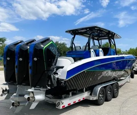 Slide: The Image of 2025 Renegade 38 Open boat with triple engines on a trailer under a blue sky. - 19