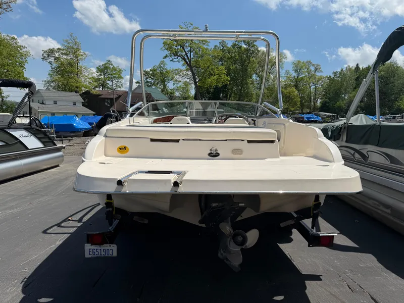 Slide: The Image of 2004 Rinker Captiva boat, rear view, parked outdoors under a clear sky. - 1
