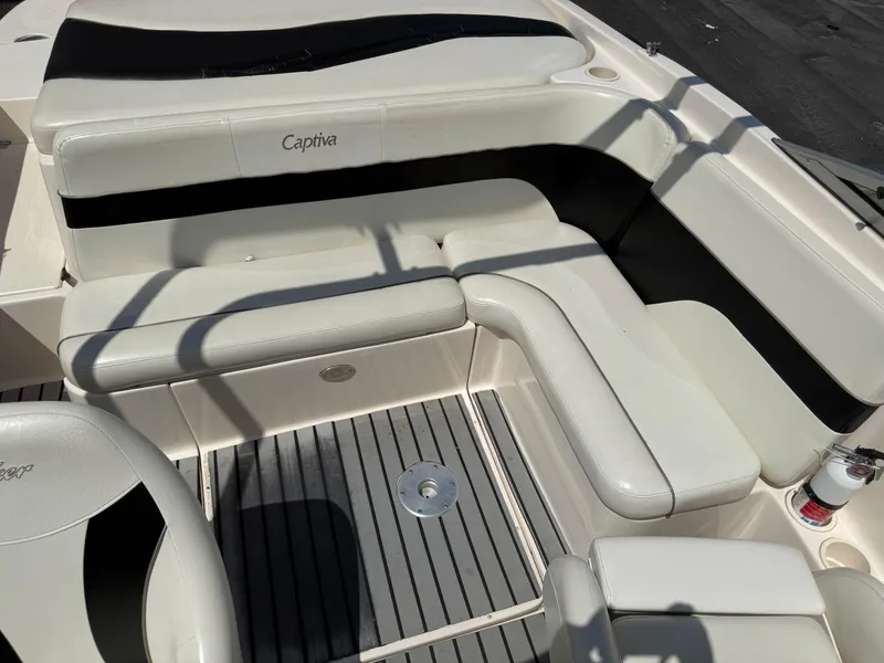 Slide: The Image of 2004 Rinker Captiva boat interior with white and black seating and gray flooring. - 10
