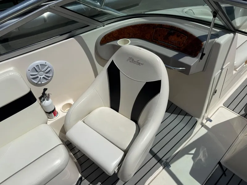 Slide: The Image of 2004 Rinker Captiva boat interior with white seating and wood accents. - 14