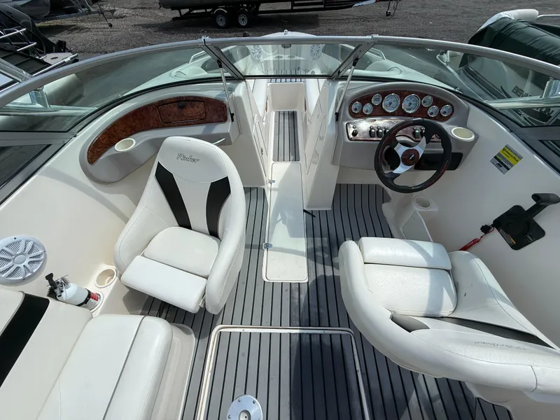Slide: The Image of 2004 Rinker Captiva boat interior with white seating and modern dashboard controls. - 19