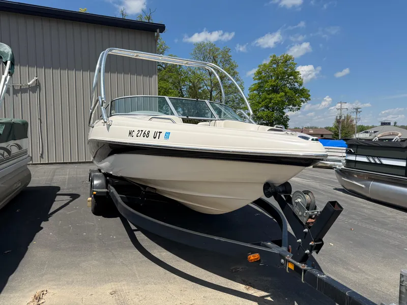Slide: The Image of 2004 Rinker Captiva boat on trailer, parked outdoors under clear blue sky. - 2