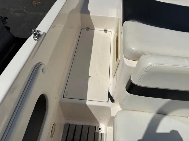 Slide: The Image of 2004 Rinker Captiva boat interior with white seating and storage compartment. - 20