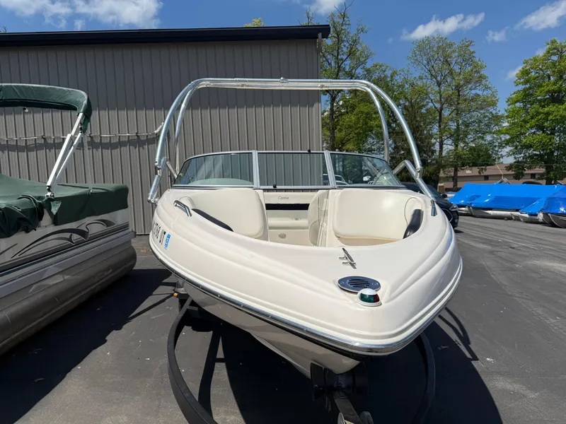 Slide: The Image of 2004 Rinker Captiva boat with white exterior, parked outdoors on a sunny day. - 4