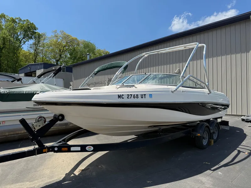 Slide: The Image of 2004 Rinker Captiva boat on trailer, parked outdoors near a building. - 5