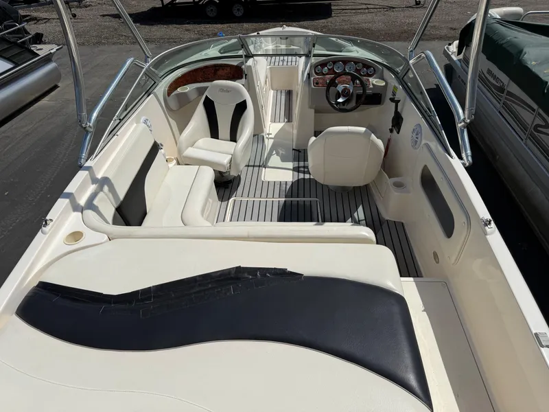 Slide: The Image of 2004 Rinker Captiva boat interior with white seating and steering console. - 9