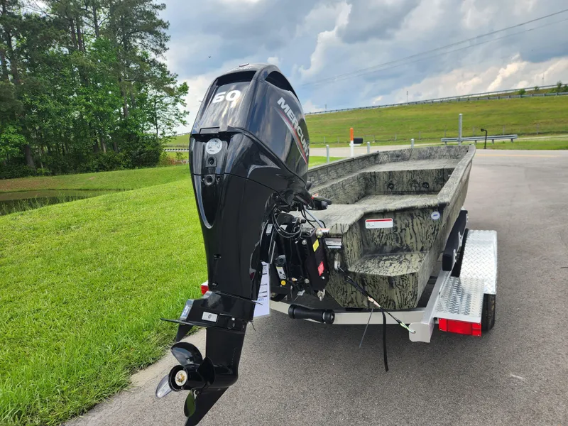 Slide: The Image of 2025 Tracker Grizzly 1650 T Prairie Wings Edition boat on trailer, parked on a paved road. - 3